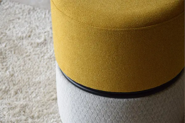 Taburete bajo tapizado mostaza y gris
