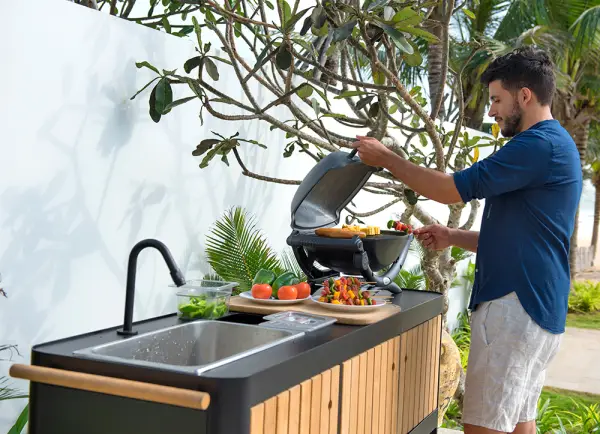 Cocina de exterior en alumnio negro y madera de teca