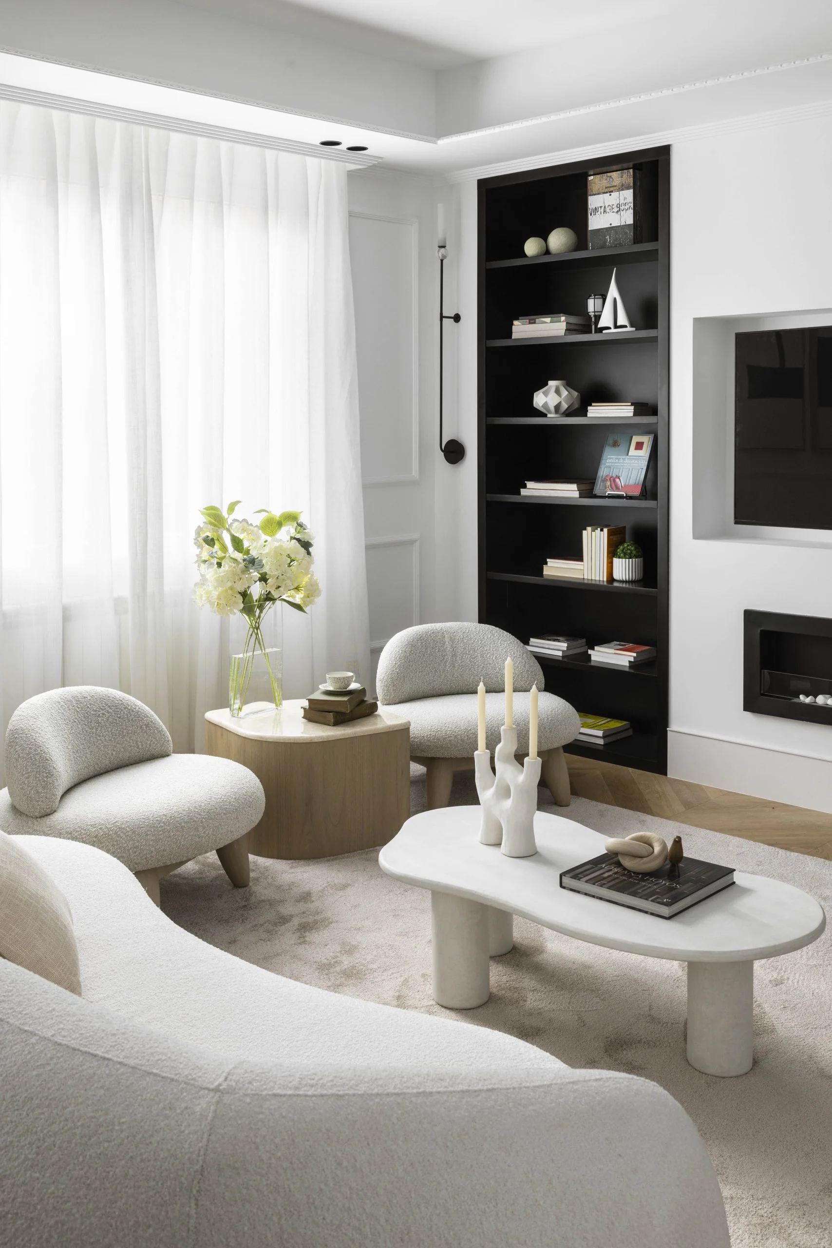 Salón en tonos neutros con librería integrada en una vivienda del Barrio de Salamanca, Madrid